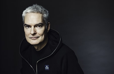 Der Autor Max Bentow steht vor einem Dunklen Hintergrund