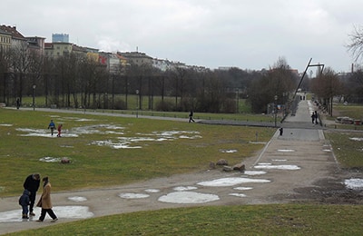 Park in Kreuzkölln, in dem Besucher auf asphaltierten Wegen spazieren.