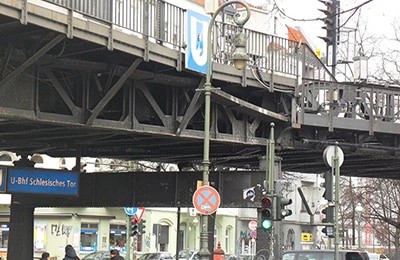 Industrielle Brücke über befahrener Straße und U-Bahn-Schild 
