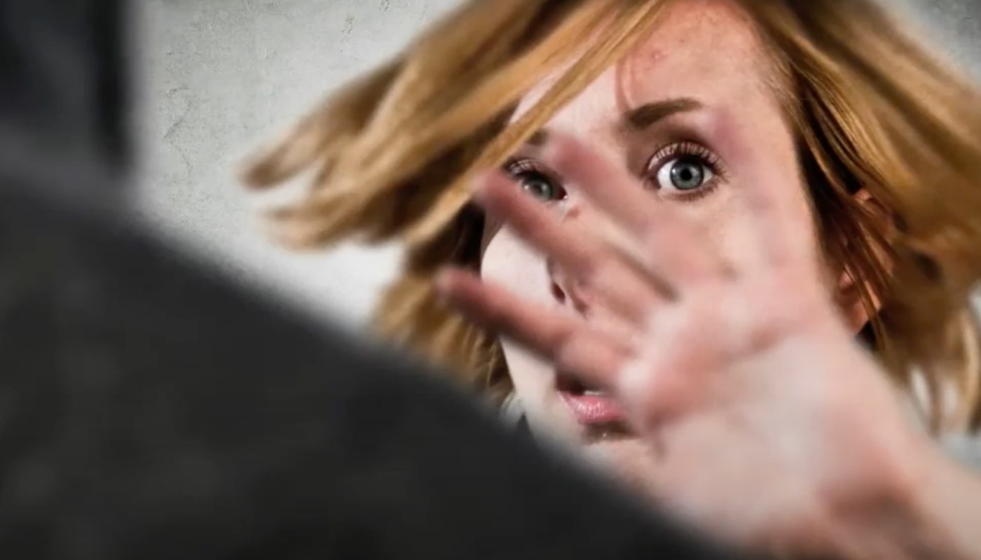 Eine Frau wehrt mit der Hand etwas von sich ab.